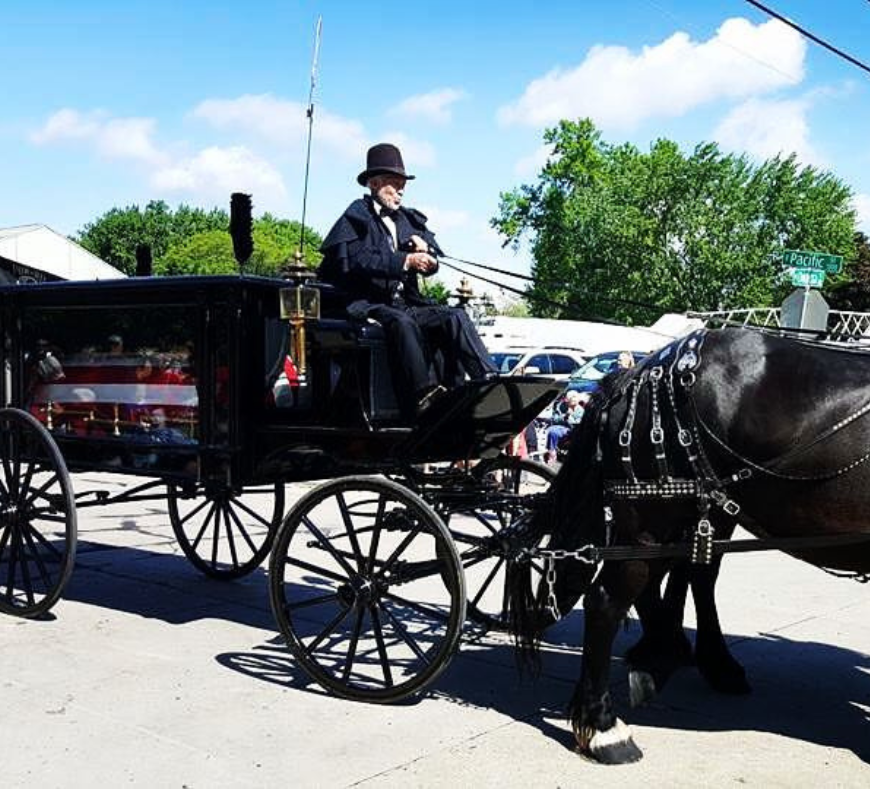 Rodger Cavanaugh with a horse-drawn hearse, showcasing carriage rides for special occasions including funerals