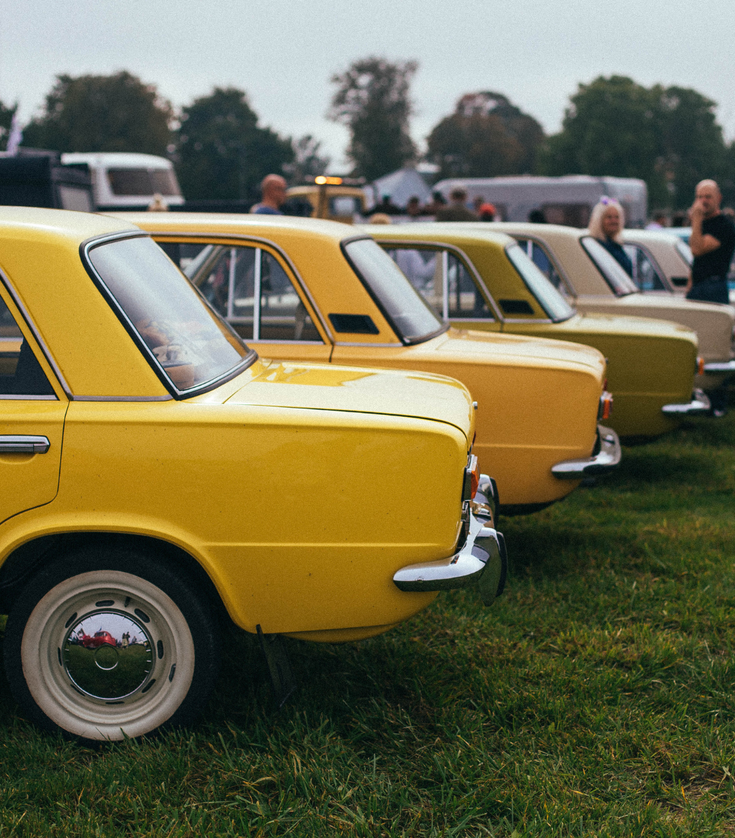 A vibrant classic car show featuring vintage vehicles on display, organized by Cavanaugh Carriages