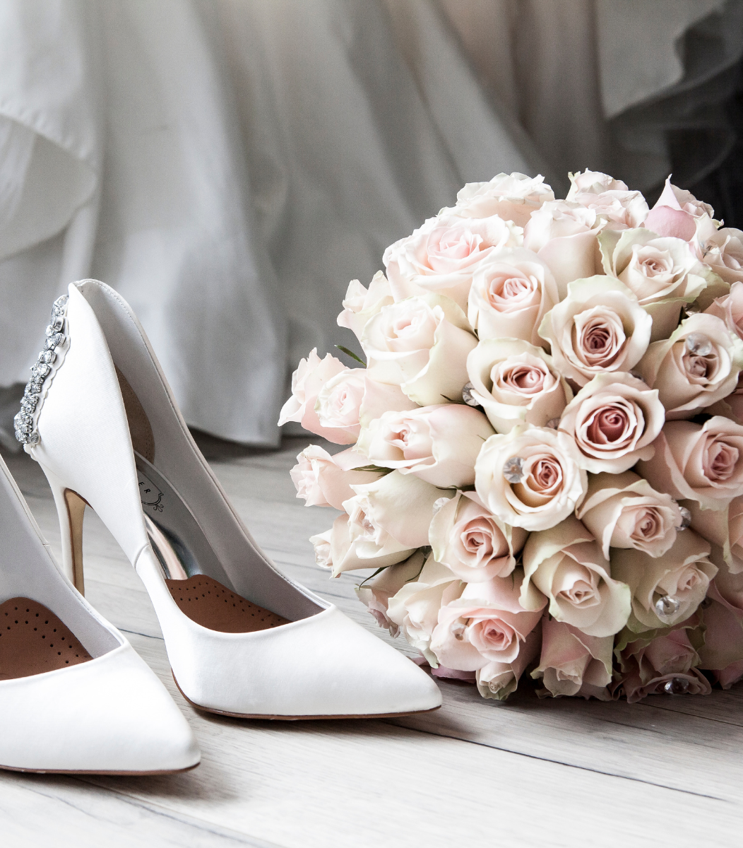 Elegant wedding shoes paired with a beautiful floral arrangement, symbolizing the charm of Cavanaugh Carriages' wedding services
