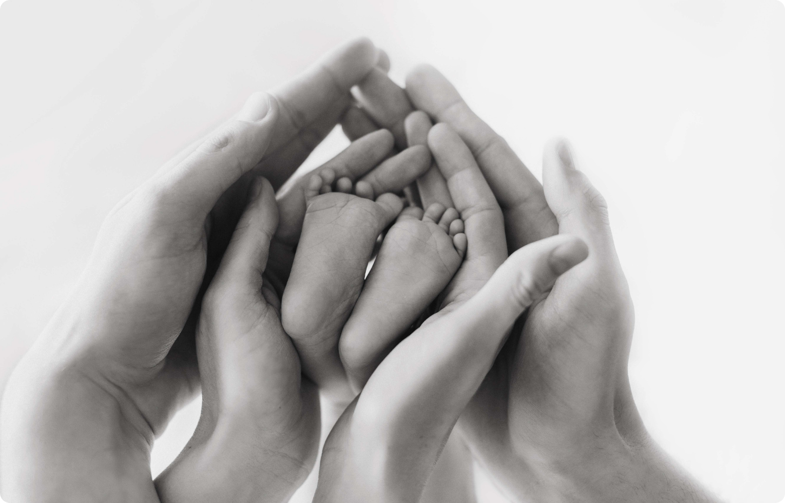 A child's tiny foot cradled gently by a parent's hands, symbolizing the warmth and joy of baby showers, gender reveals, and other cherished celebrations for growing families hosted by Cavanaugh Carriages.